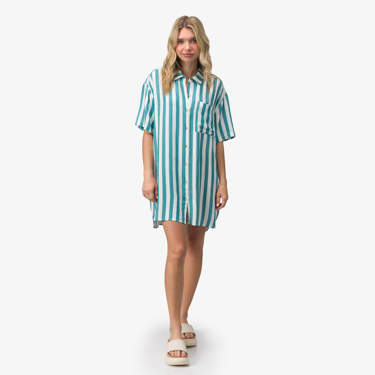 Woman wearing Ollie Shirt Dress in blue and white stripes, front view, paired with beach-inspired sandals facing forward.