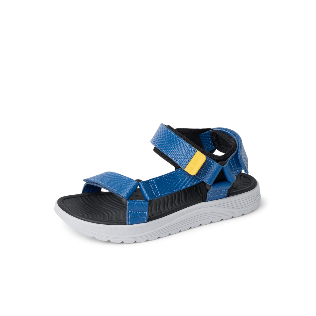 Kids Shoremazing sandal facing left, blue straps with black footbed and white sole, surf-inspired comfort for boys.