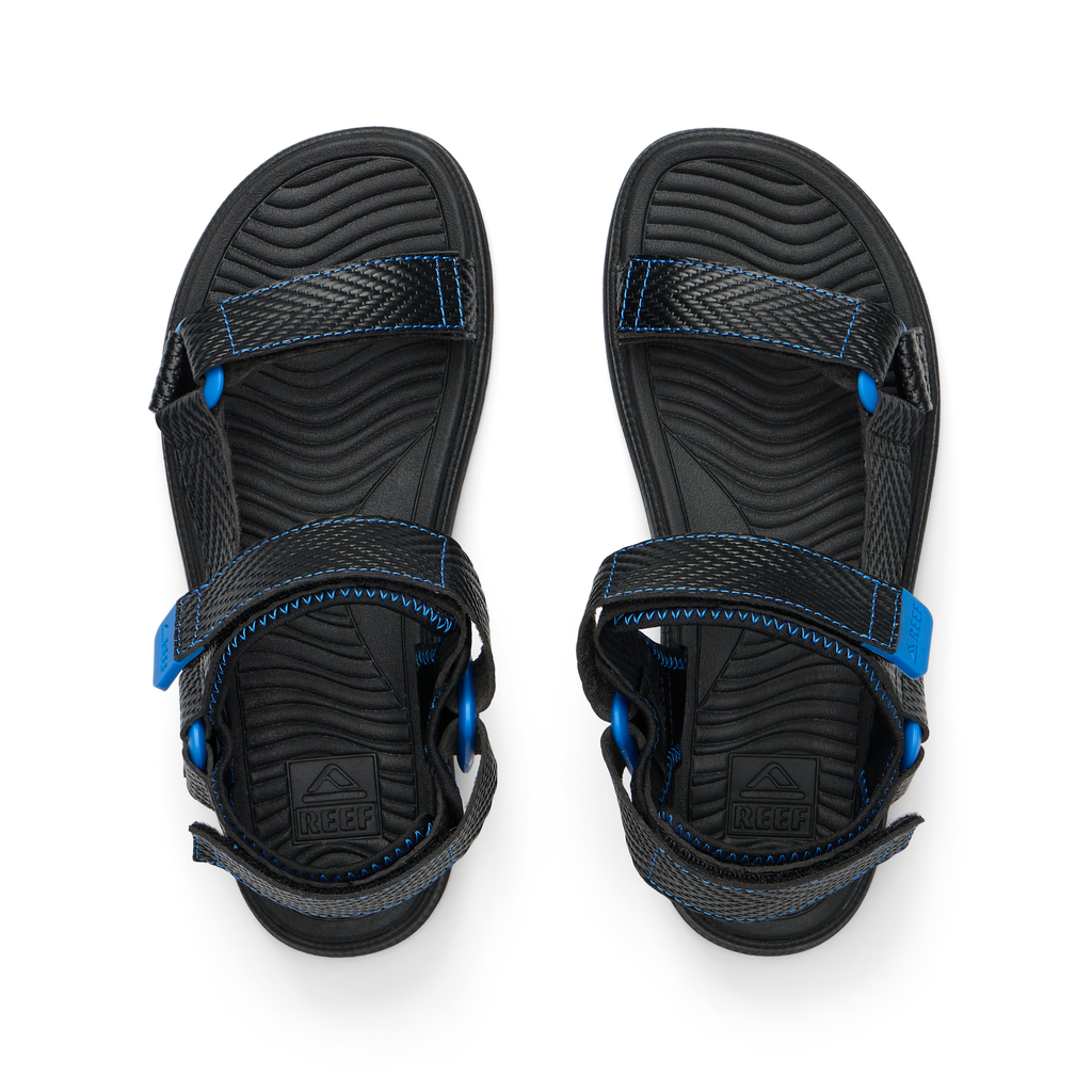 Kids Shoremazing black and blue sandals top view facing upward, showing adjustable straps and cushioned footbeds for comfort.