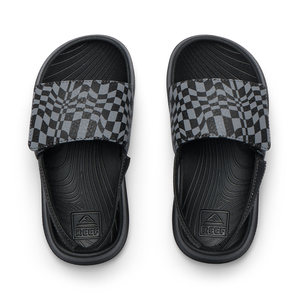 Pair of Little Salty Slide sandals for boys facing up, featuring black checker pattern and anatomical arch support.