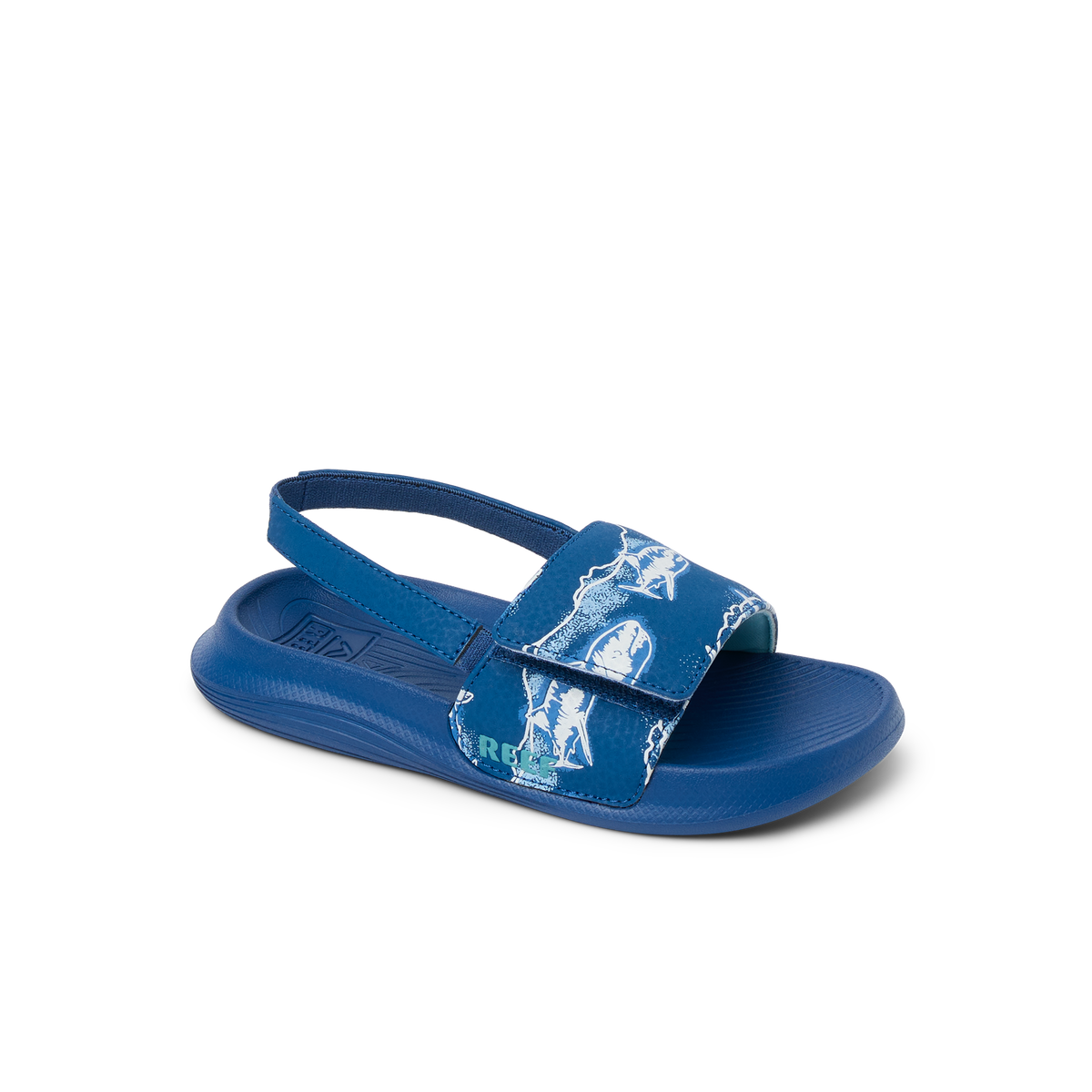 Little Salty Slide boys’ sandal facing left, close-up of front strap with surf-inspired print and cushioned sole.