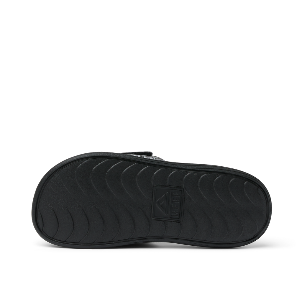 Kids Salty Slide black slide sandal sole facing upward, showing durable water-friendly rubber outsole for comfort.