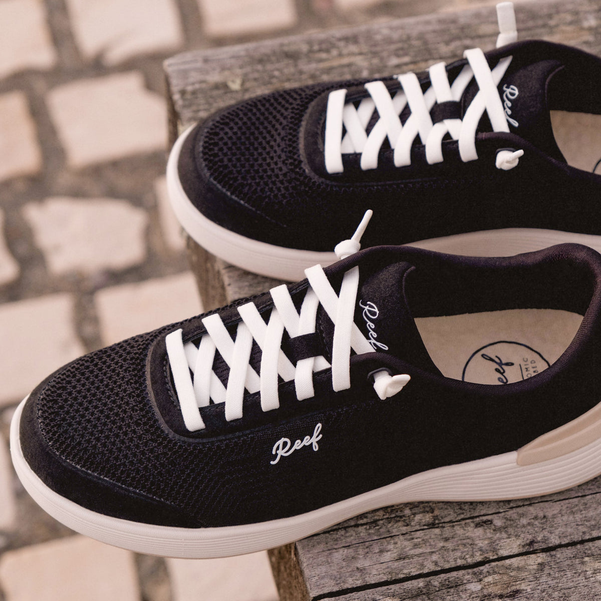 Shoreline Palisades black sneakers facing right, close-up of upper and laces, beach-inspired comfort and support.