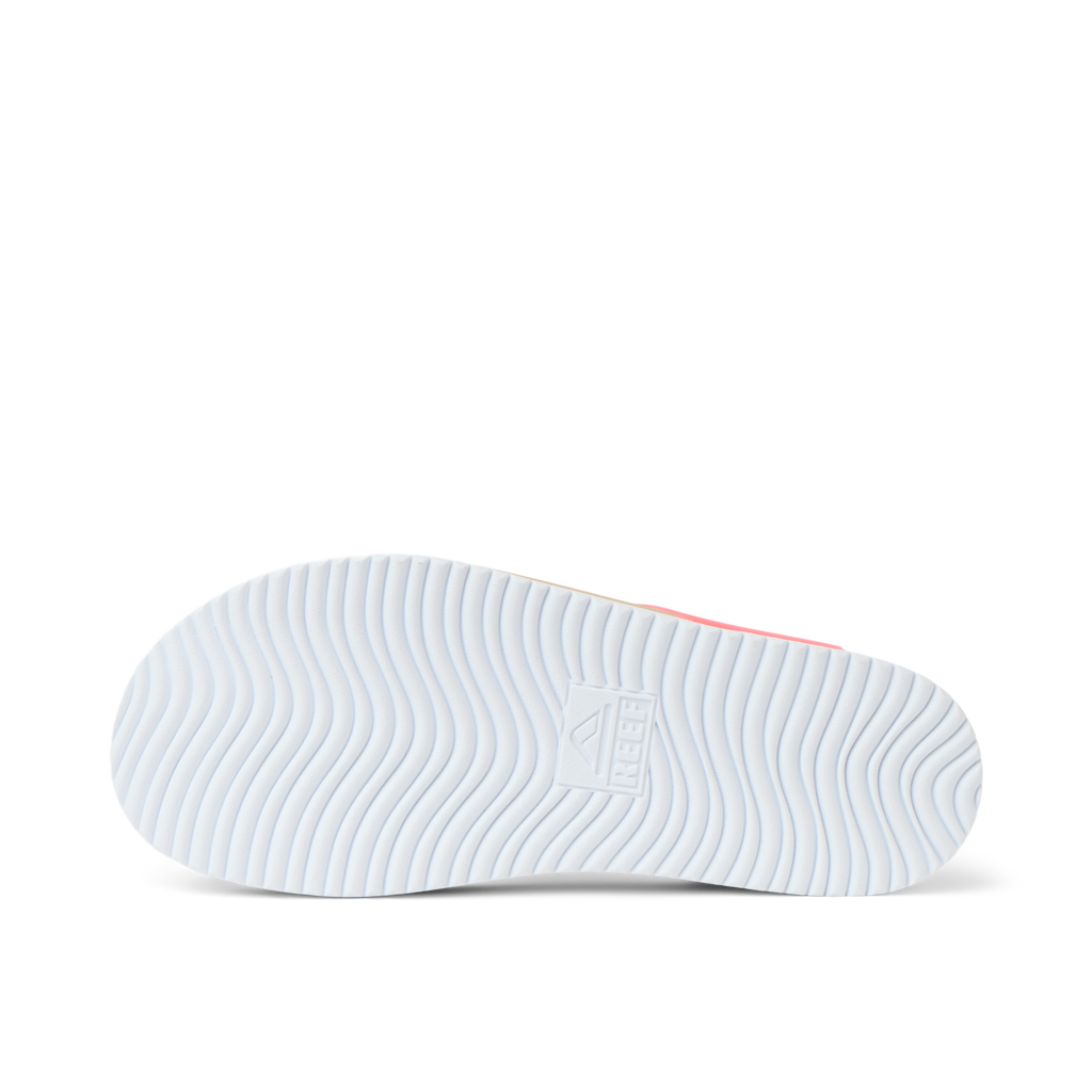 Kids Cali Coastin shoe sole facing up, showing REEF logo and wavy tread pattern for durable, beach-ready comfort.