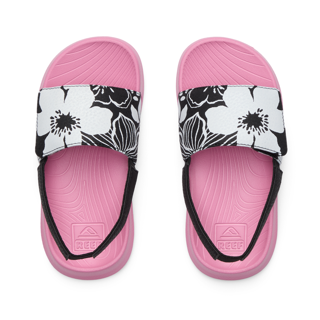 Top view of pink Little Salty Slide sandals for girls with black and white floral straps, designed for comfort and beach use.