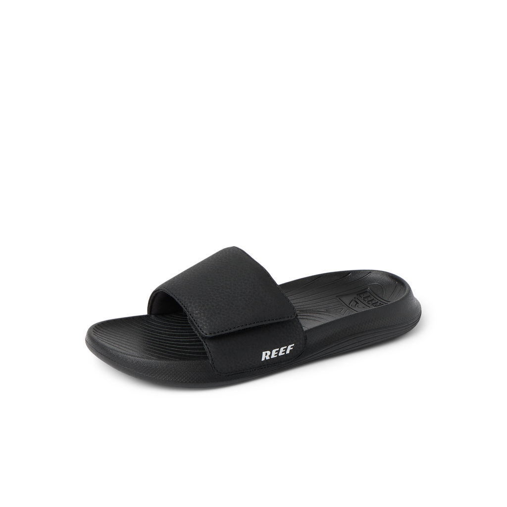 Kids Salty Slide in black facing left, close-up of the top and side showing cushioned footbed and adjustable strap.
