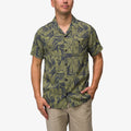 Man wearing Kantis Shirt with moss green tropical leaf pattern, front view, beach-inspired comfort apparel for men.