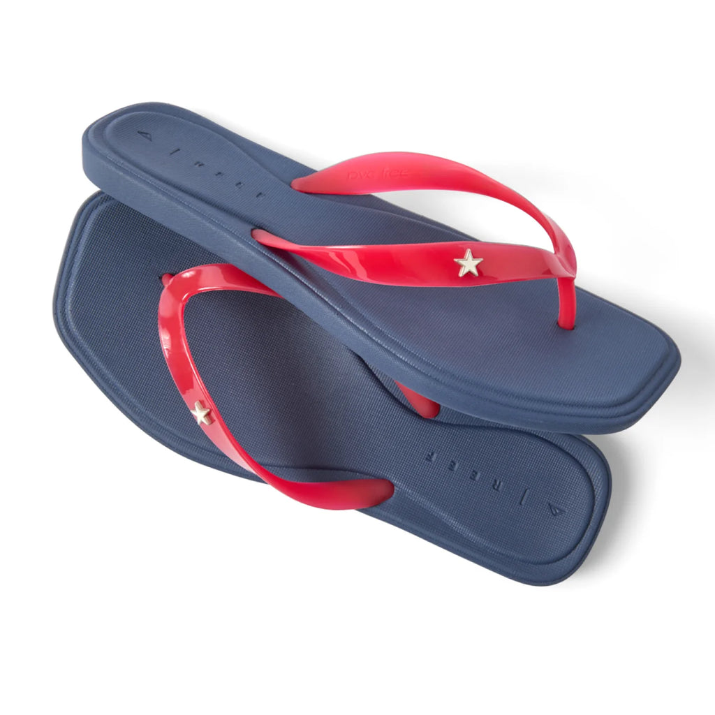 Pair of Solaye sandals for women, navy blue soles facing up and red straps with star detail, close-up of top and side view.