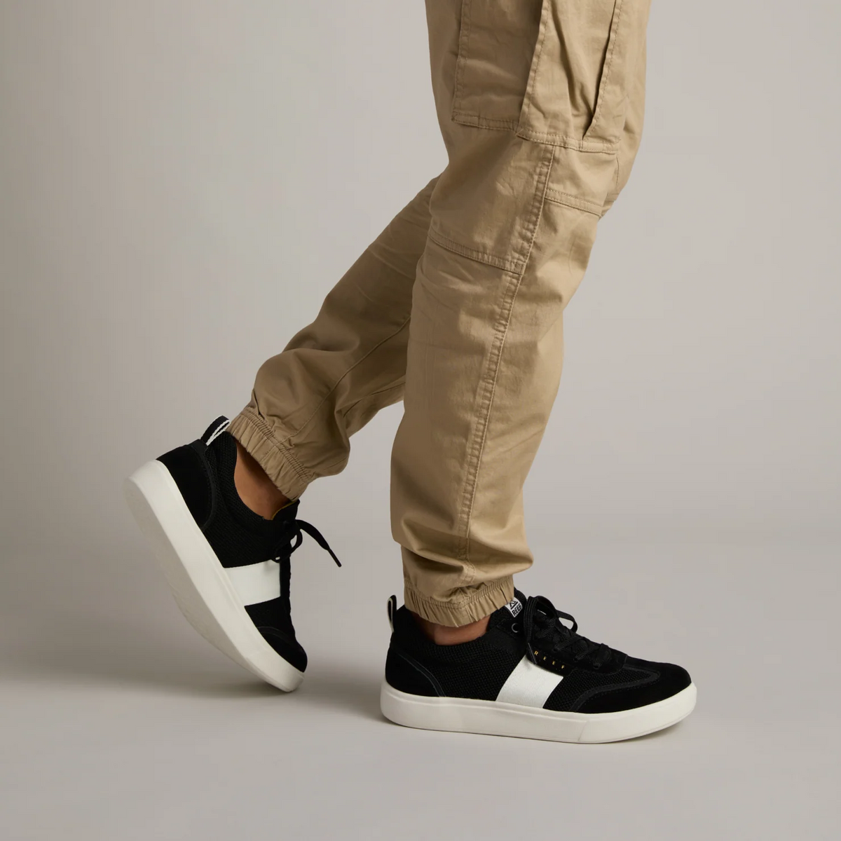 Side view of Triton black men's sneaker on foot, featuring lightweight, cushioned comfort and durable sole for beach and everyday wear.