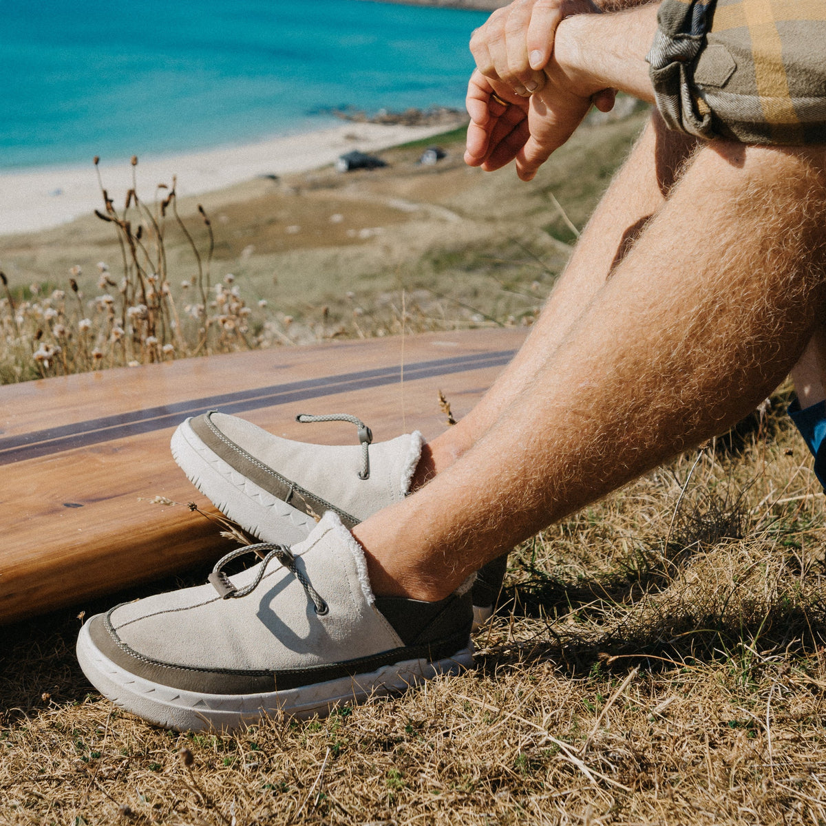 Rambler gray suede shoes facing left outdoors near the beach