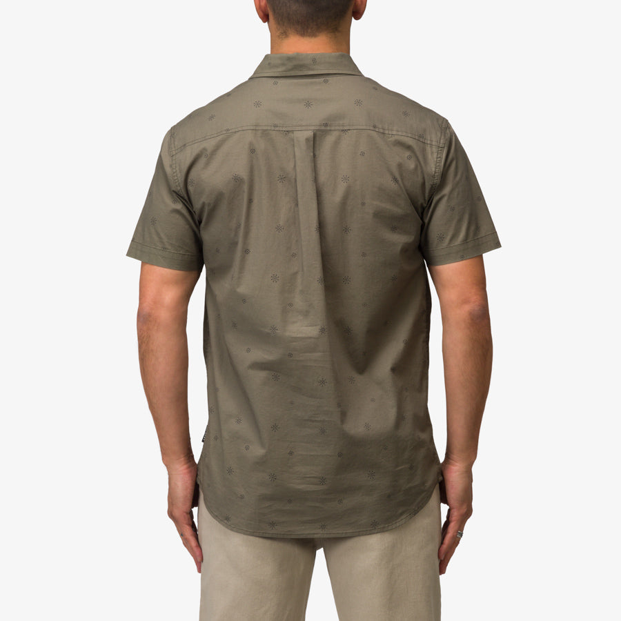 Back view of a man wearing the olive Topaz Shirt, showcasing its comfortable, beach-inspired casual style.